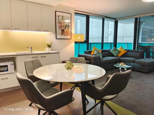 een keuken en een woonkamer met een tafel en stoelen bij Adelaide City Loft in Adelaide