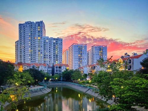 uma cidade com edifícios altos e um rio ao pôr do sol em LAKEVIEW Park Villa - Private Pool, BBQ, Karaoke em Cidade de Ho Chi Minh