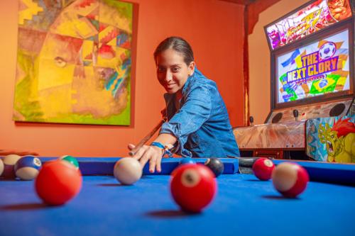 a woman playing pool at a pool table at Hotel Route 66 in Vichayito