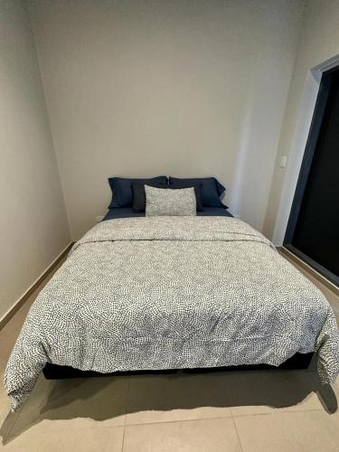 1 dormitorio con 1 cama grande con almohadas azules en Bosques de Mayo en Maipú