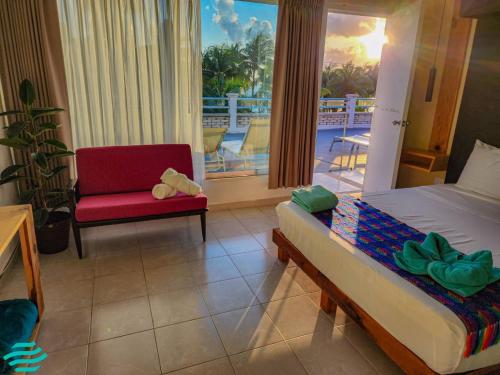 a bedroom with a bed and a chair and a balcony at Antillas in Isla Mujeres