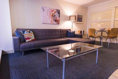 a living room with a couch and a glass table at PI702 - Ideally Located Sydney CBD in Sydney