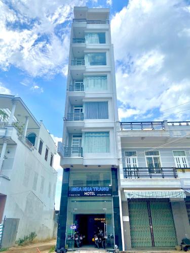 un grand bâtiment blanc avec un magasin devant lui dans l'établissement Isea Nha Trang Hotel, à Nha Trang
