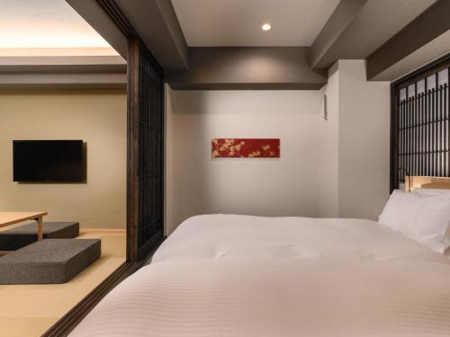 a bedroom with a bed and a tv at MIMARU Kyoto Nishinotoin Takatsuji in Kyoto