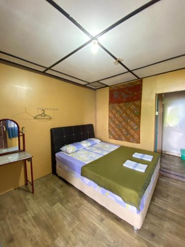 Sri Sentosa Chalet في جزيرة تيومان: غرفة نوم بسرير في غرفة مع طاولة