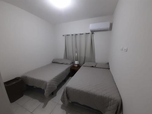 聖米蓋爾的住宿－House in San Miguel, Res. San Andres，一间卧室设有两张床,墙上配有一盏灯。