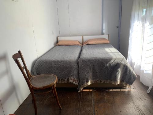 Ce lit se trouve dans un dortoir doté d'une chaise et d'un siège social. dans l'établissement Casa Contenedor y espacio verde, à Paysandú
