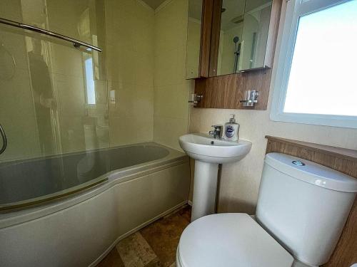 łazienka z toaletą, umywalką i wanną w obiekcie Lovely Caravan With Decking At Manor Park, Near Hunstanton Beach Ref 23034c w mieście Hunstanton