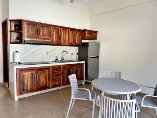 a kitchen with wooden cabinets and a table and chairs at Casa Boutique Maria Bonita in La Manzanilla