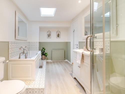 a bathroom with a tub and a toilet and a sink at Mrs Crackers Cottage in Lund