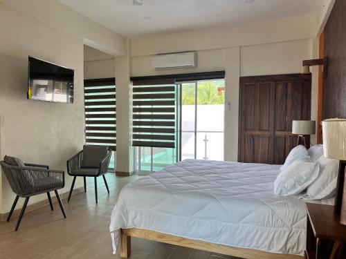 a bedroom with a bed and a table and a chair at Casa Boutique Maria Bonita in La Manzanilla