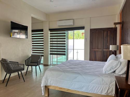 - une chambre avec un lit, une table et une chaise dans l'établissement Casa Boutique Maria Bonita, à La Manzanilla