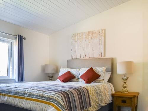 a white bedroom with a bed with pillows at Lodge 38 in Stonham Aspall