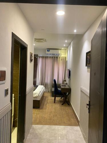 a corridor of a hospital room with a bed and a desk at Hotel Milton in Islamabad