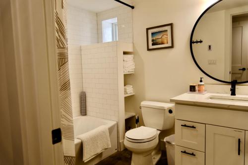 a bathroom with a toilet and a sink and a mirror at Modern and warm house in Seattle