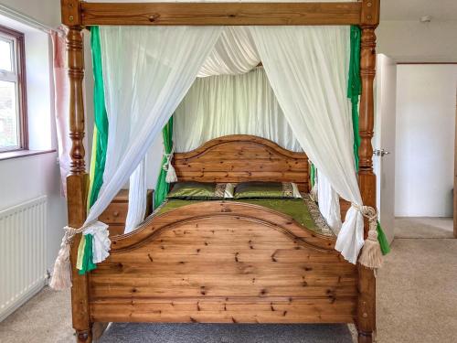 a bedroom with a wooden bed with a canopy at Chilbolton in Chilbolton