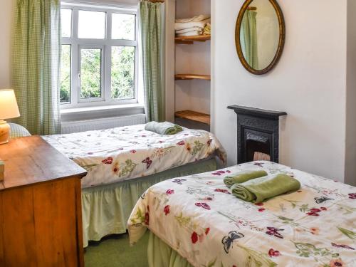 two beds in a room with a mirror at 1 Brandiston Barn Cottage in Cawston