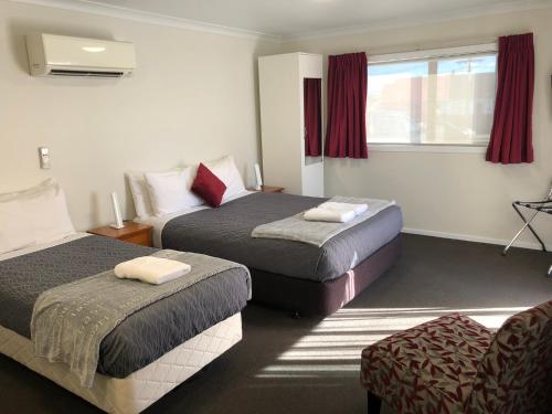 Cette chambre comprend 2 lits et une fenêtre. dans l'établissement Matariki Motor Lodge, à Te Awamutu