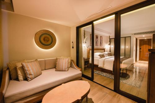 a living room with a couch and a bedroom at Ramayana Suites and Resort in Kuta