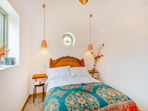 a bedroom with a bed with a colorful blanket at The Pigeons Nest in Great Bolas