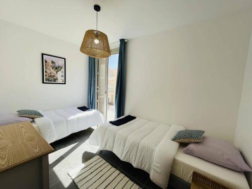 a room with two beds and a window at Appartement Calvi, 3 pièces, 4 personnes - FR-1-63-339 in Calvi