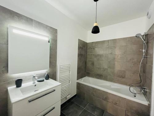 a bathroom with a sink and a bath tub and a mirror at Appartement Calvi, 3 pièces, 4 personnes - FR-1-63-339 in Calvi