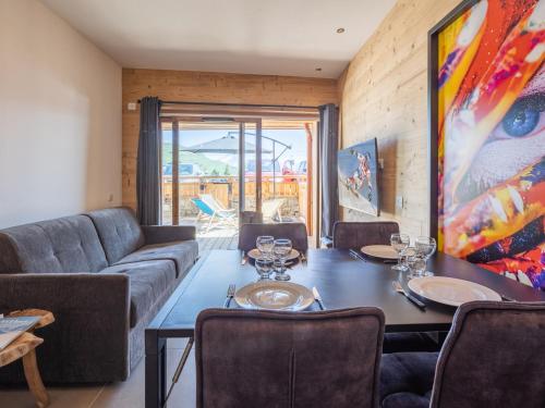 une salle à manger avec une table et un canapé dans l'établissement Appartement familial centre station avec terrasse sud et parking - FR-1-645-40, à Huez