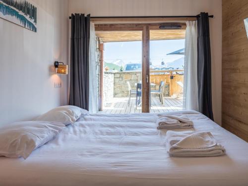 a bed with towels on it in a room with a window at Appartement Huez, 2 pièces, 4 personnes - FR-1-645-40 in LʼHuez