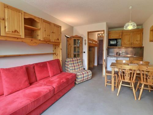 un salon avec un canapé rouge et une table dans l'établissement Charmant 2P avec Balcon S/E, Proche Pistes et Commerces, Tout Équipé - 73550 Les Allues - FR-1-182-256, à Les Allues