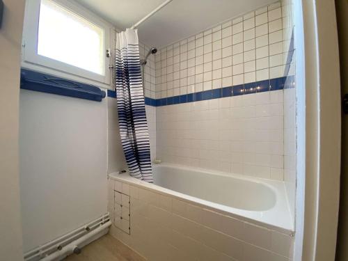 La salle de bains est pourvue d'une baignoire et d'une fenêtre. dans l'établissement Spacieux T3, 2 chambres, parking privé à Gruissan - FR-1-229-876, à Gruissan