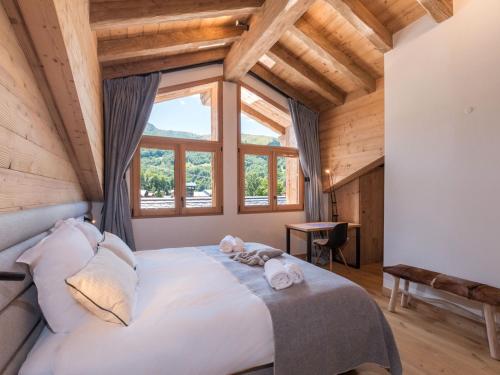 une chambre avec un grand lit avec deux animaux en peluche dessus dans l'établissement Duplex neuf 8 pers., sauna, proche centre Saint-Martin-de-Belleville - FR-1-570-49, à Saint-Martin-de-Belleville