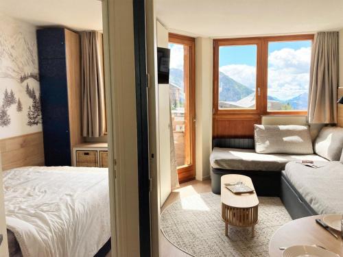 une chambre d'hôtel avec un lit et un canapé dans l'établissement Appartement rénové au cœur d'Avoriaz, 4/5 pers, avec balcon et accès internet - FR-1-634-93, à Morzine