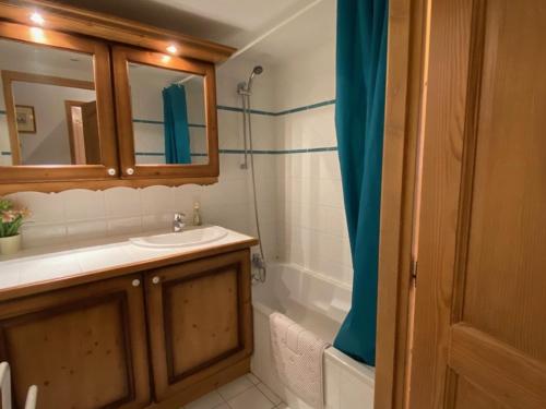 a bathroom with a sink and a mirror and a tub at Appartement Crest-Voland, 3 pièces, 6 personnes - FR-1-733-140 in Crest-Voland