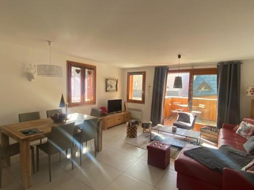 un salon avec une table et une salle à manger dans l'établissement Appartement spacieux, proche pistes et commerces, avec balcon sud et garage privatif - FR-1-445-193, à Montgenèvre