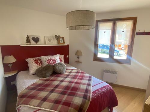 une chambre avec un lit avec deux animaux en peluche dessus dans l'établissement Appartement spacieux, proche pistes et commerces, avec balcon sud et garage privatif - FR-1-445-193, à Montgenèvre