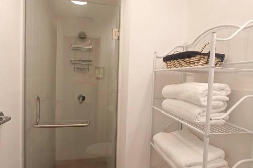 a bathroom with a shower and a rack with towels at Encantador y Panorámico Apartamento in Guatemala