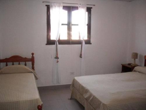 a bedroom with two beds and a window at Hosteria Sol de la quebrada in Humahuaca
