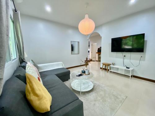 a living room with a couch and a tv at Baan Patcharintorn Samui in Chaweng
