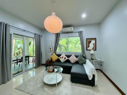 a living room with a couch and a glass table at Baan Patcharintorn Samui in Chaweng