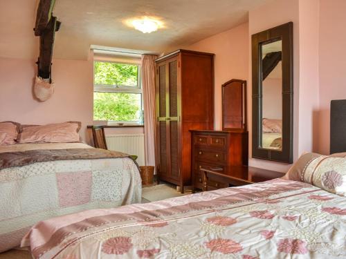 a bedroom with two beds and a dresser and a mirror at High Spy in Bassenthwaite