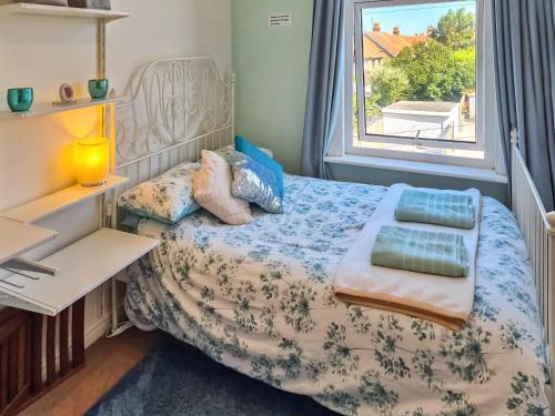 a small bedroom with a bed with a window at Hillrise in Herne Bay