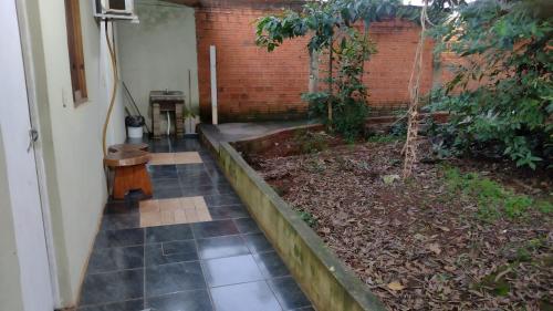 um jardim com um banco ao lado de uma parede de tijolos em Liart Hospedajes em Puerto Iguazú