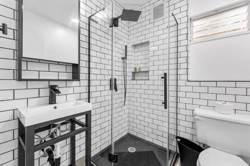 a white bathroom with a sink and a toilet at Seabreeze Hideaway B 30 Night Minimum in Honolulu