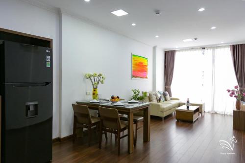 a kitchen and living room with a table and a couch at Pegasy Apartments & Travel in Hanoi