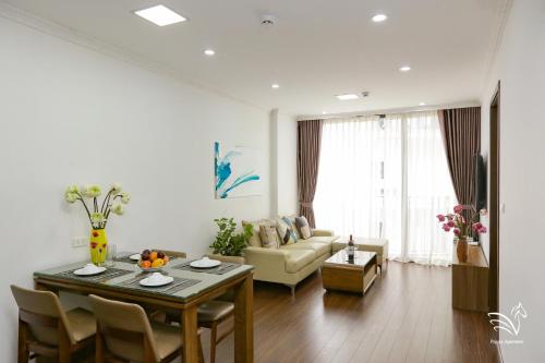 a living room with a table and a couch at Pegasy Apartments & Travel in Hanoi