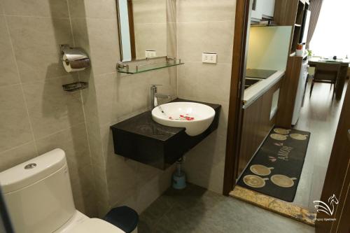 a bathroom with a white toilet and a sink at Pegasy Apartments & Travel in Hanoi