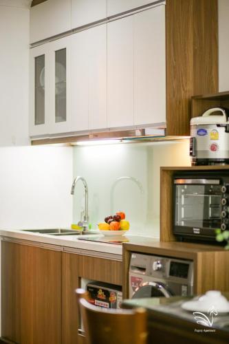 a kitchen with a microwave and a bowl of fruit at Pegasy Apartments & Travel in Hanoi