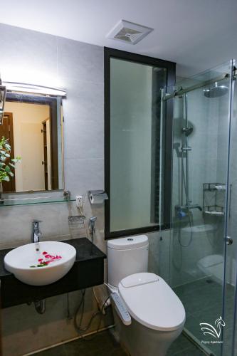 a bathroom with a toilet and a sink and a shower at Pegasy Apartments & Travel in Hanoi