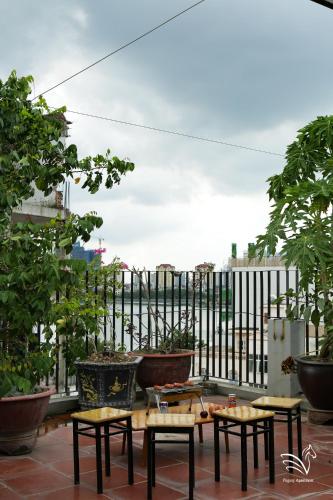 a patio with a table and chairs and a fence at Pegasy Apartments & Travel in Hanoi