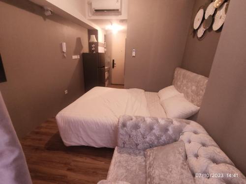 a bedroom with a bed and a couch in it at Apartemen Tokyo Riverside PIK2 tower Chikusei 